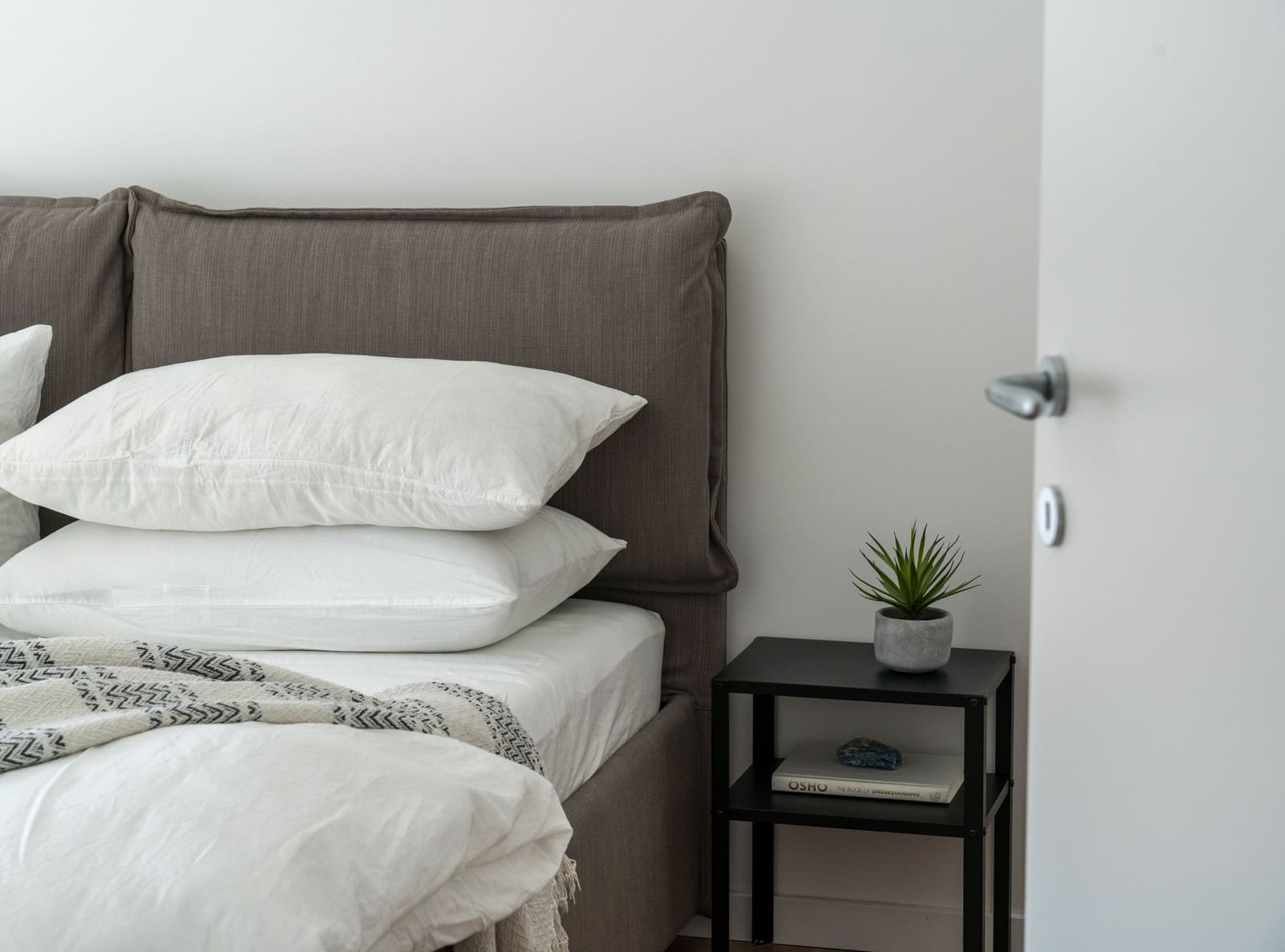 Cama hecha con sábanas blancas